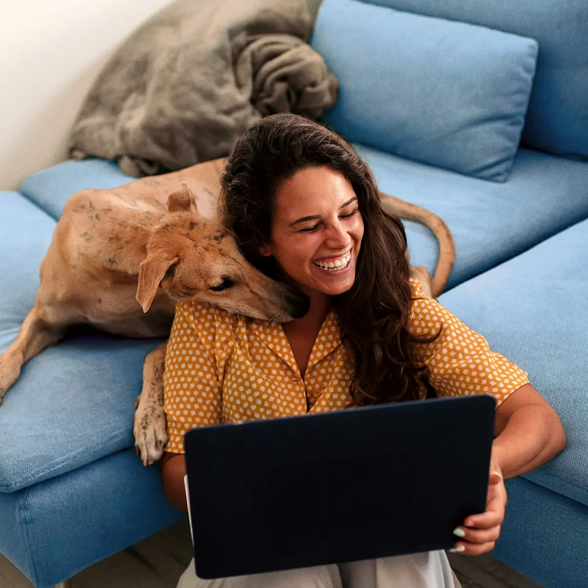 Frau mit Laptop auf dem Sofa